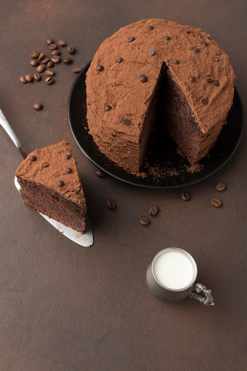 Foto gratuito alto angolo di torta al cioccolato con cacao in polvere e latte
