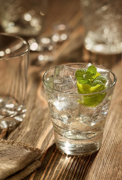 Foto gratuito bicchiere di gin tonic con lime e ghiaccio su un tavolo di legno. avvicinamento. natura morta. copia spazio