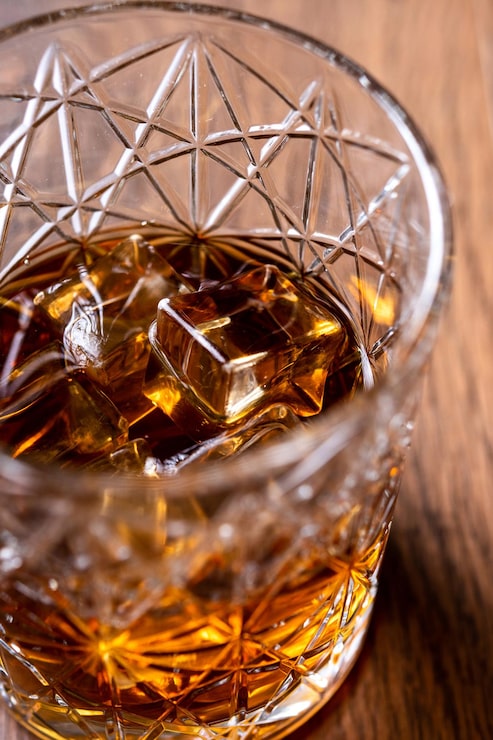 Foto gratuito bicchiere di whisky scozzese su tavola di legno