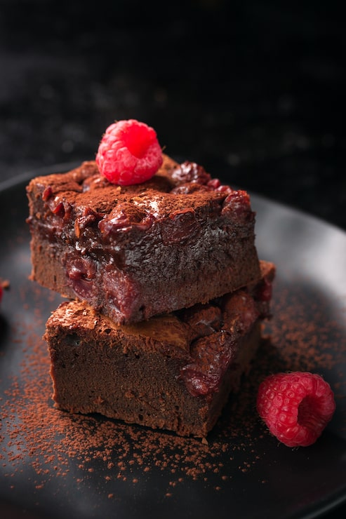 Foto gratuito brownie con lamponi e cacao in polvere