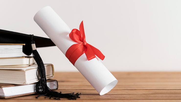 Foto gratuito certificato con nastro e fiocco e libri