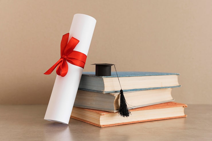 Foto gratuito certificato di diploma di istruzione e piccolo cappello da laurea