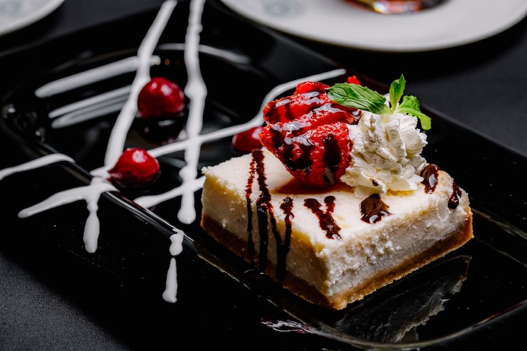 Foto gratuito cheesecake con crema di fragole marmellata ciliegia vista laterale
