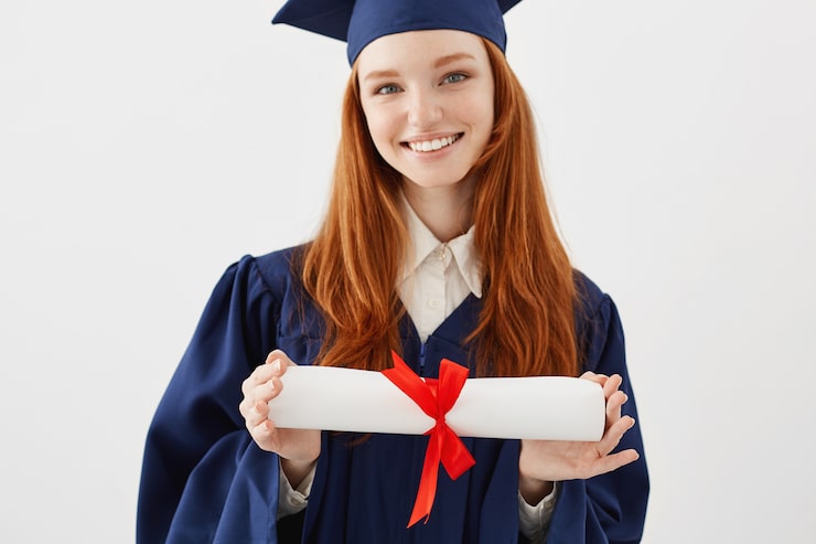 Foto gratuito chiuda sul ritratto del laureato sexy felice della donna in diploma sorridente della tenuta del cappuccio. avvocato o ingegnere futuro della giovane studentessa della testarossa.