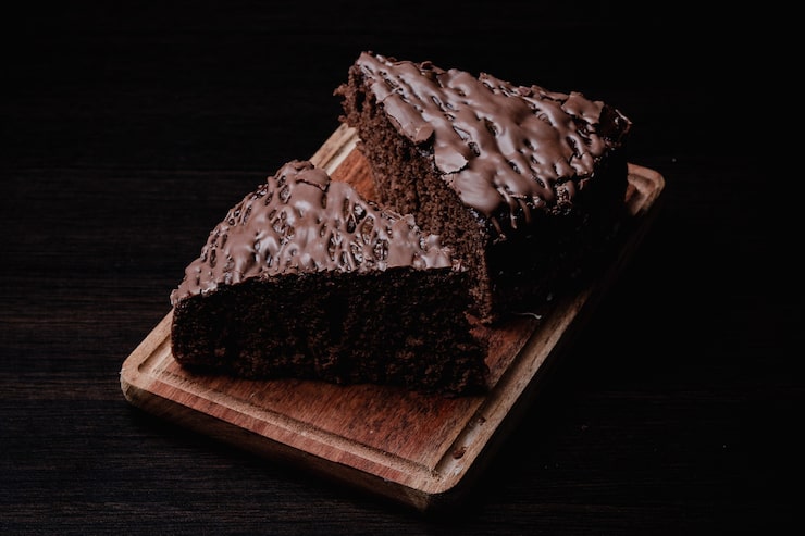 Foto gratuito close-up di due pezzi di gustosa torta al cioccolato su una tavola di legno