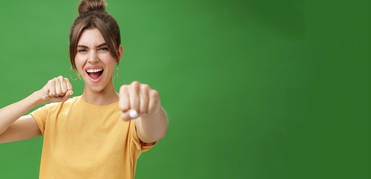 Foto gratuito cucina ribelle donna in maglietta gialla con i denti a fessura che tira il pugno verso la telecamera come se mostrasse un combattimento