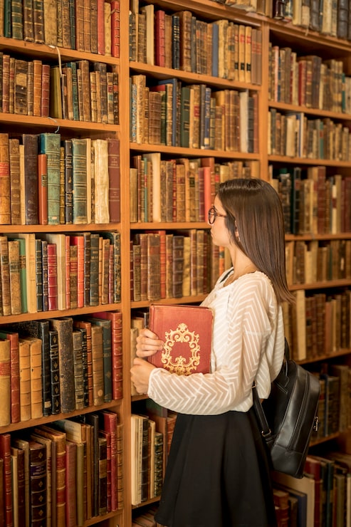 Foto gratuito donna intelligente con un libro in biblioteca