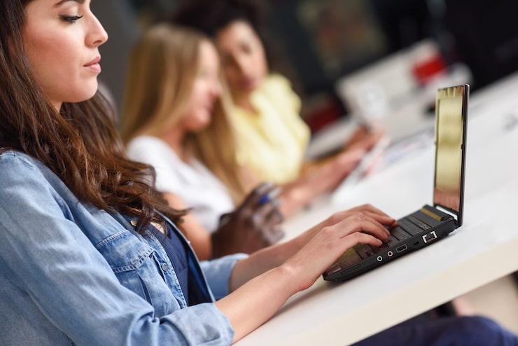 Foto gratuito giovane donna che studia con computer portatile sulla scrivania bianca.
