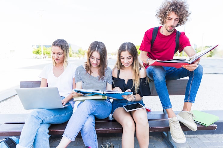 Foto gratuito giovani amici che studiano sulla panchina