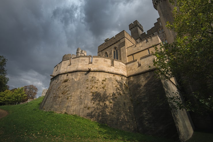 Foto gratuito inquadratura dal basso del castello e della cattedrale di arundel circondati da un bellissimo fogliame