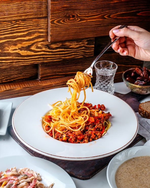 Foto gratuito pasta di vista frontale con carne macinata sul pavimento marrone