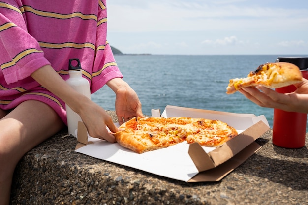 Persone che si godono uno spuntino di pizza all'aperto
