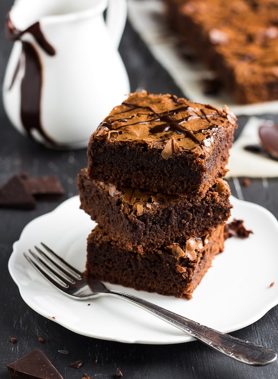Foto gratuito pezzi di torta al brownie al cioccolato impilati su un piatto di pasticcini fatti in casa