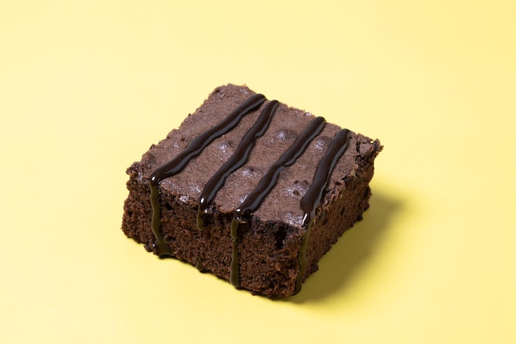 Foto gratuito porzione di brownie al cioccolato su sfondo giallo
