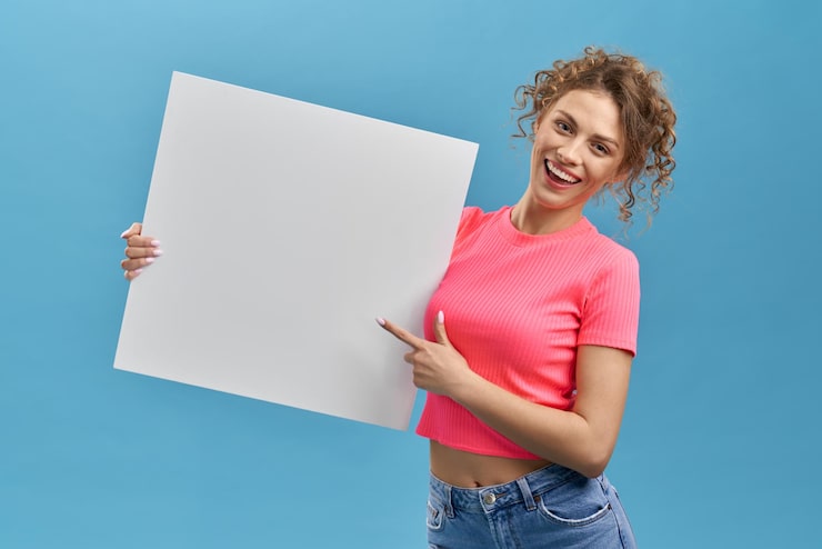 Foto gratuito ragazza riccia che sorride con la tavola bianca in mano