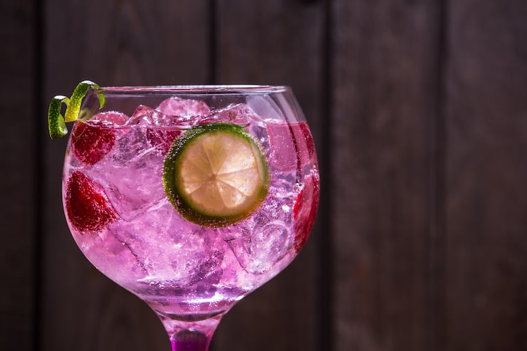 Foto gratuito scatto ravvicinato di gin tonic rose con lamponi e lime