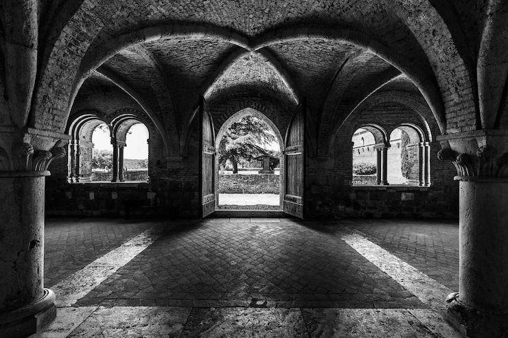 Foto gratuito scena in scala di grigio all'interno dell'abbazia di san galgano in toscana, italia con disegno di pareti ad arco