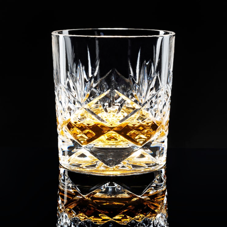 Foto gratuito scotch whisky dorato su sfondo nero