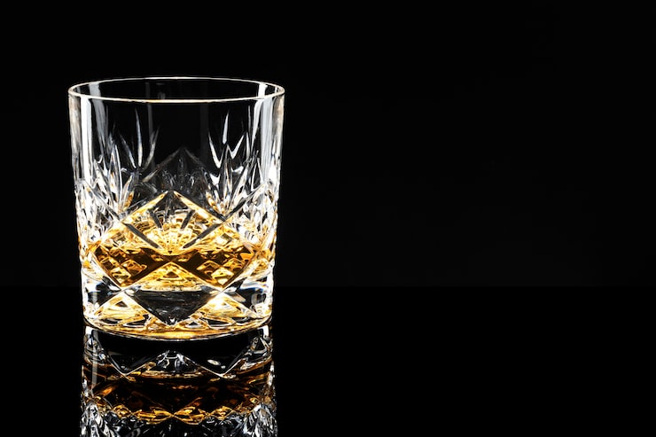 Foto gratuito scotch whisky dorato su sfondo nero