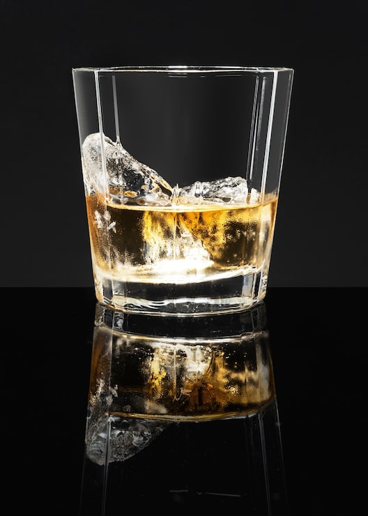 Foto gratuito scotch whisky dorato su sfondo nero