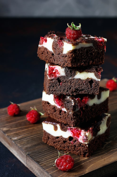 Foto gratuito torre di brownies con cheesecake e lamponi