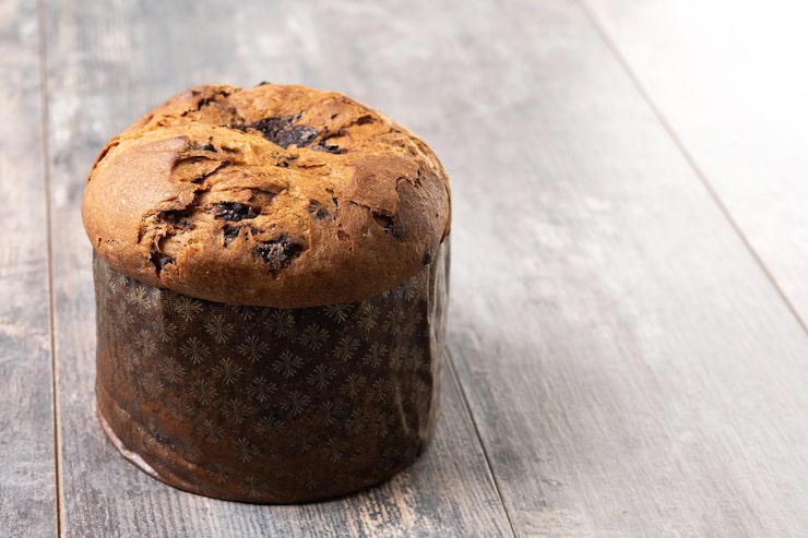 Foto gratuito torta di panettone di natale con cioccolatini su un tavolo di legno