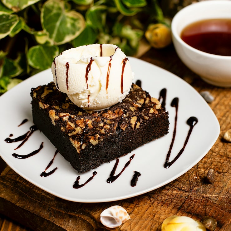 Foto gratuito una fetta di biscotto al cioccolato con gelato alla vaniglia e noci.