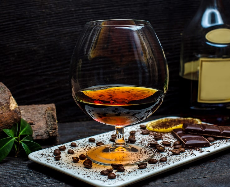 Foto gratuito vaso di cognac e barrette di cioccolato