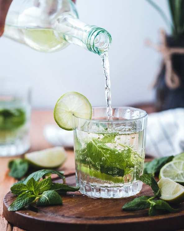 Foto gratuito versare acqua con lime in una tazza di vetro