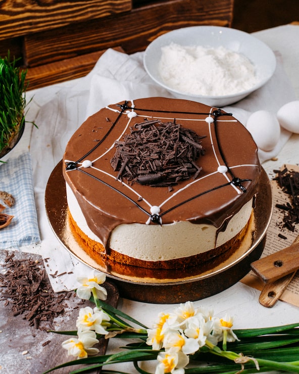 Foto gratuito vista laterale di una torta di tiramisu coperta di cioccolatine sul tavolo