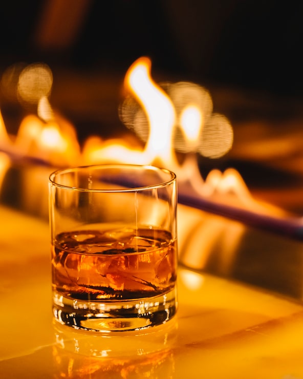 Foto gratuito whisky con cubetti di ghiaccio sul camino