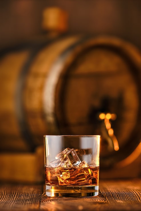 Foto bicchiere di whisky con ghiaccio con canna