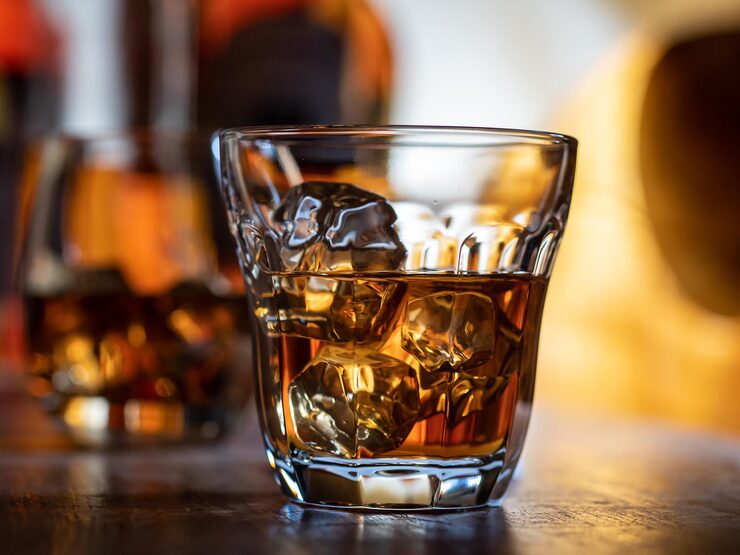 Foto bicchiere di whisky sulle rocce su un bar in legno