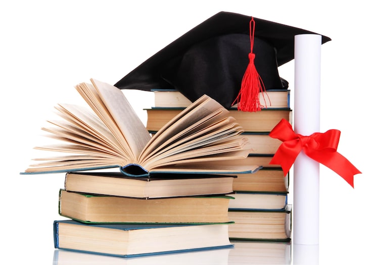 Foto cappello di laurea con diploma e libri isolati su bianco