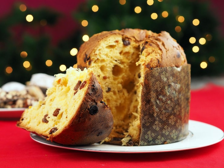 Foto deliziosa fetta di panettone con frutta candita messa a fuoco selettiva