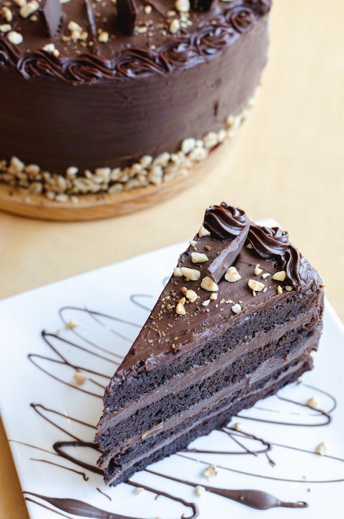 Foto deliziosa torta al cioccolato fondente con arachidi nel piatto bianco