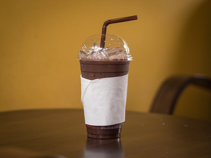 Photo es cokelat dalam gelas plastik tinggi.