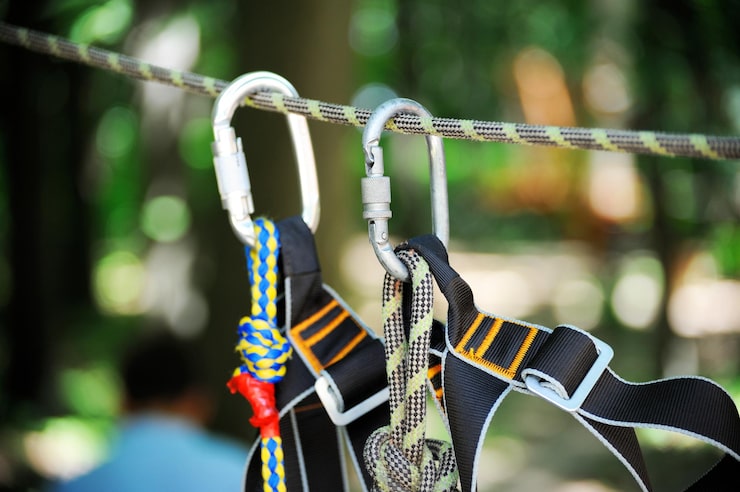 Photo gambar olahraga panjat tebing dari carabiner pada tali di hutan