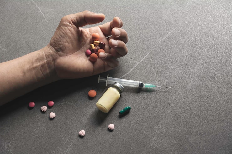 Photo gambar tangan yang dipotong dari seseorang dengan obat-obatan di lantai