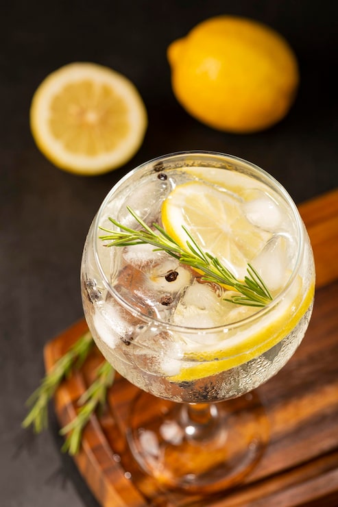 Foto gin tonic guarnito con limone e rosmarino