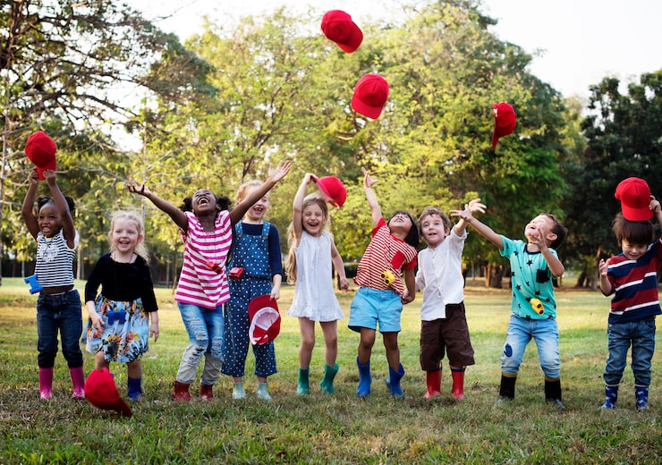 Foto gruppo di diversi bambini che giocano insieme al campo