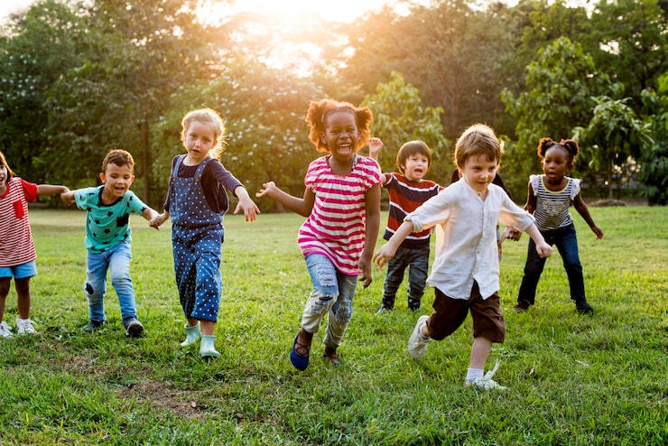 Foto gruppo di diversi bambini che giocano insieme al campo
