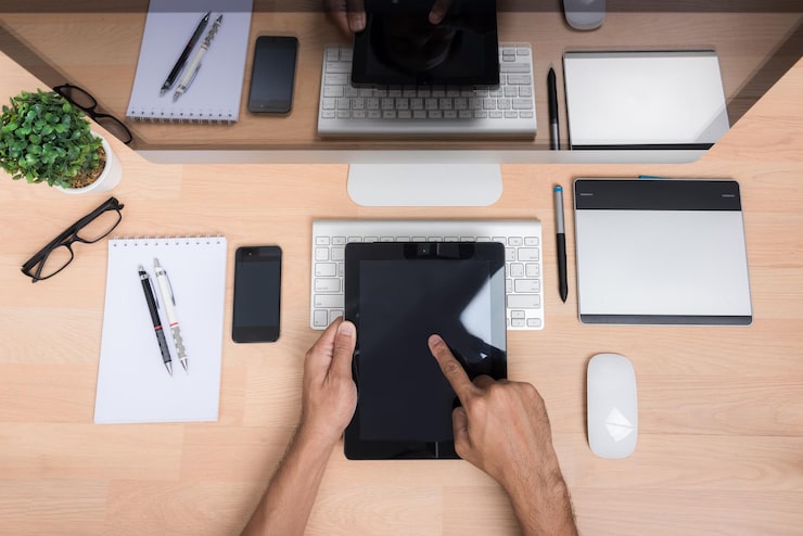 Photo pandangan sudut tinggi seseorang menggunakan teknologi digital di atas meja