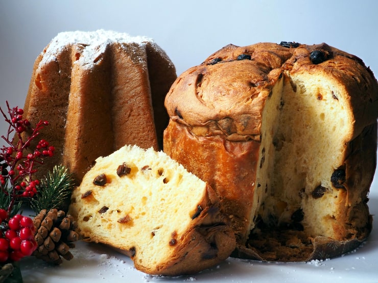 Foto panettone natalizio italiano intero e fette con frutta candita e uvetta su sfondo bianco