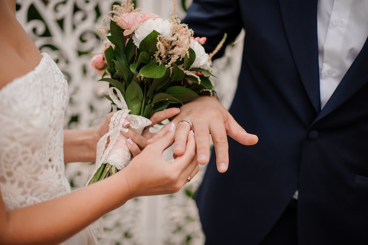 Photo pengantin baru bertukar cincin, pengantin wanita memasangkan cincin di tangan pengantin pria