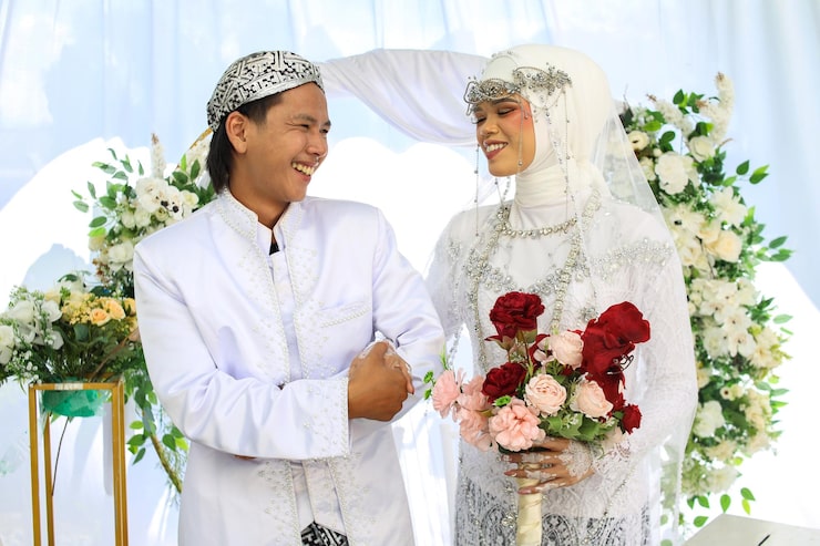 Photo pengantin pria dan wanita bahagia tersenyum sambil bergandengan tangan bersama di pernikahan indonesia