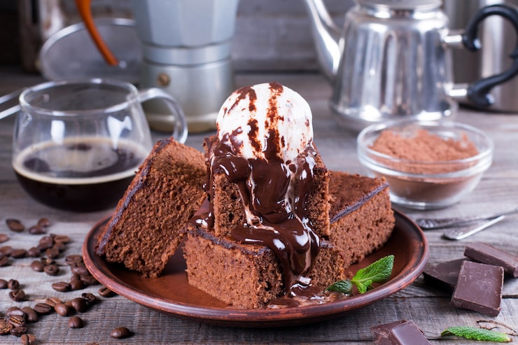 Foto torta al cioccolato con gelato e salsa al cioccolato sulla piastra sul tavolo di legno