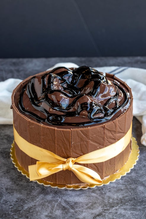 Foto torta di compleanno con profiteroli su uno sfondo scuro da vicino