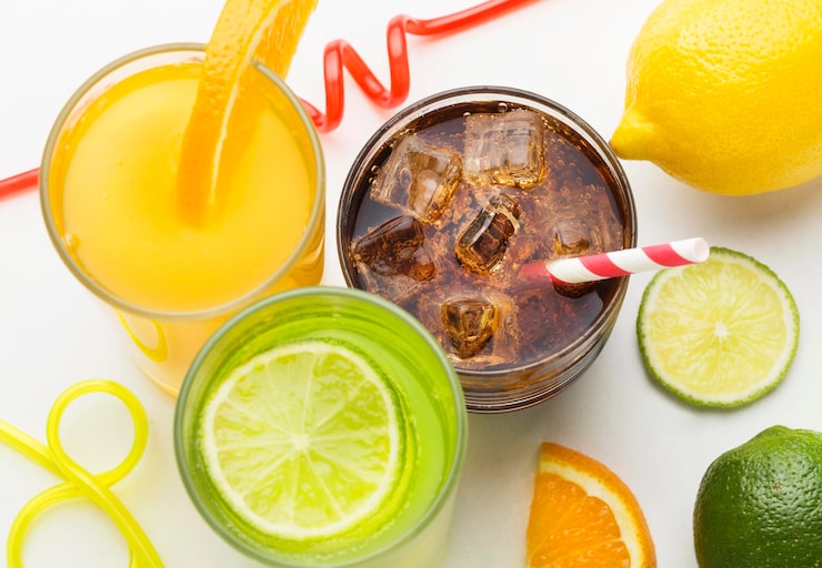 Foto grátis ângulo alto dos copos com refrigerante e suco de frutas com canudinho