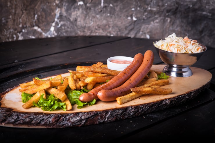 Foto grátis cachorro-quente grelhado, batata frita, ketchup e salada em uma tábua